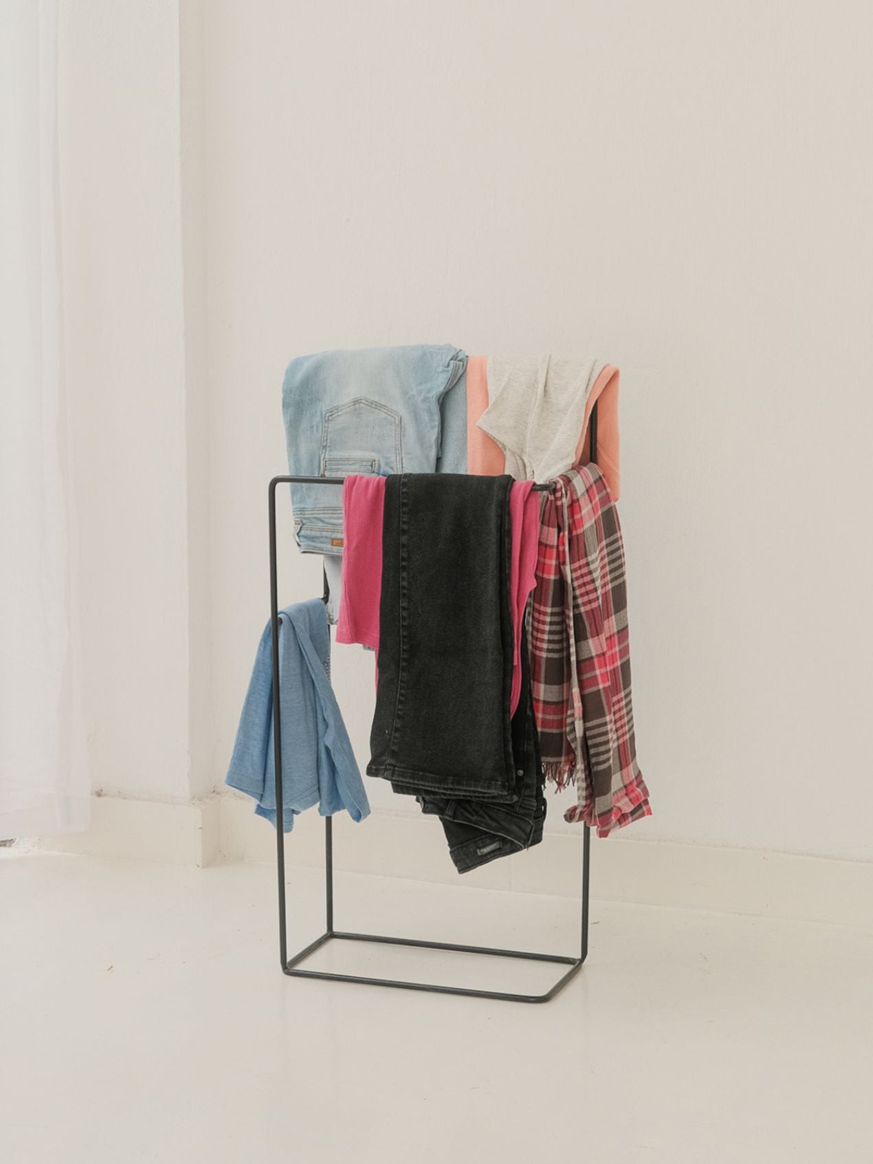 Clothing rack with folded clothes on a white background